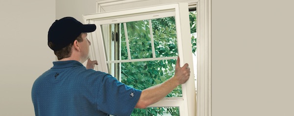 a window installer is installing new windows on a home